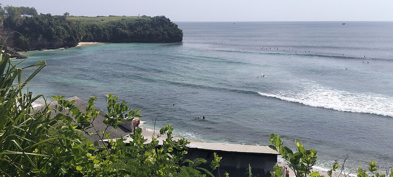 Surfer auf Wellen in der Bucht von Balangan Beach auf Bali