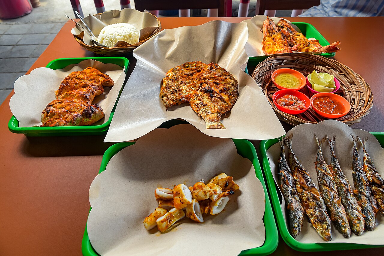 Teller mit gegrilltem Fisch, Garnelen, Sardinen und mehreren Sambal-Saucen in Kedonganan, Bali