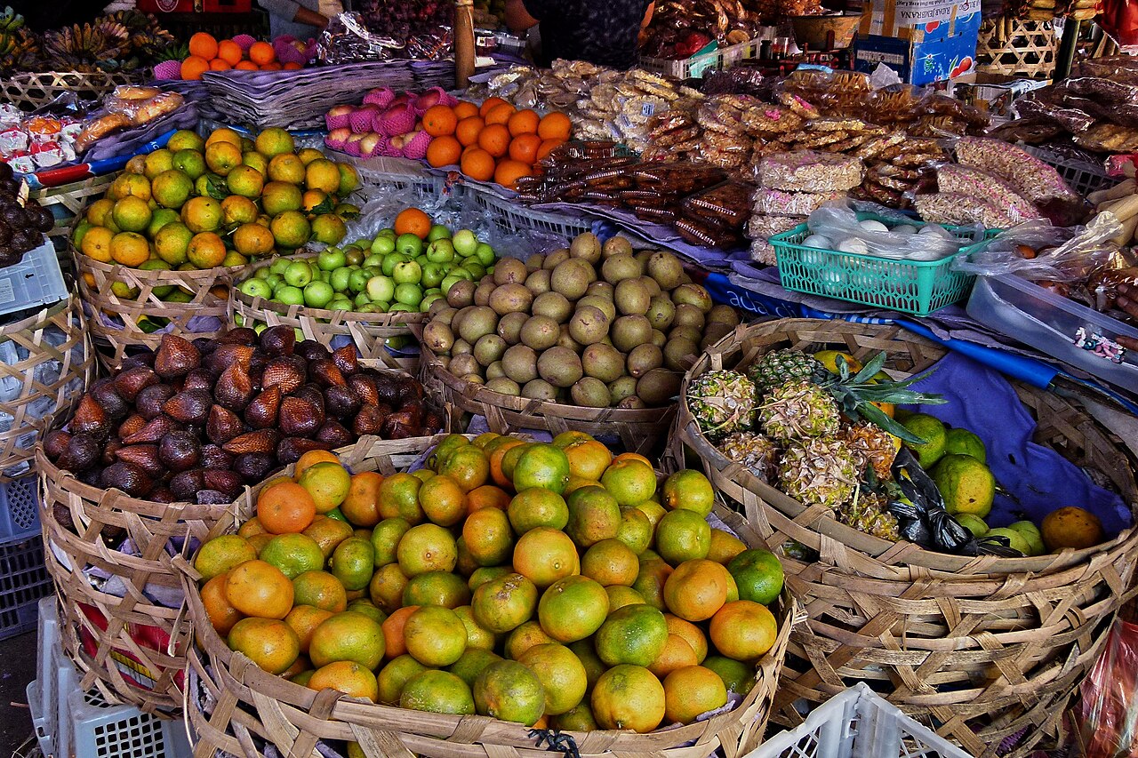 Bunte Obstkörbe mit Orangen, Salak und Ananas auf einem balinesischen Markt
