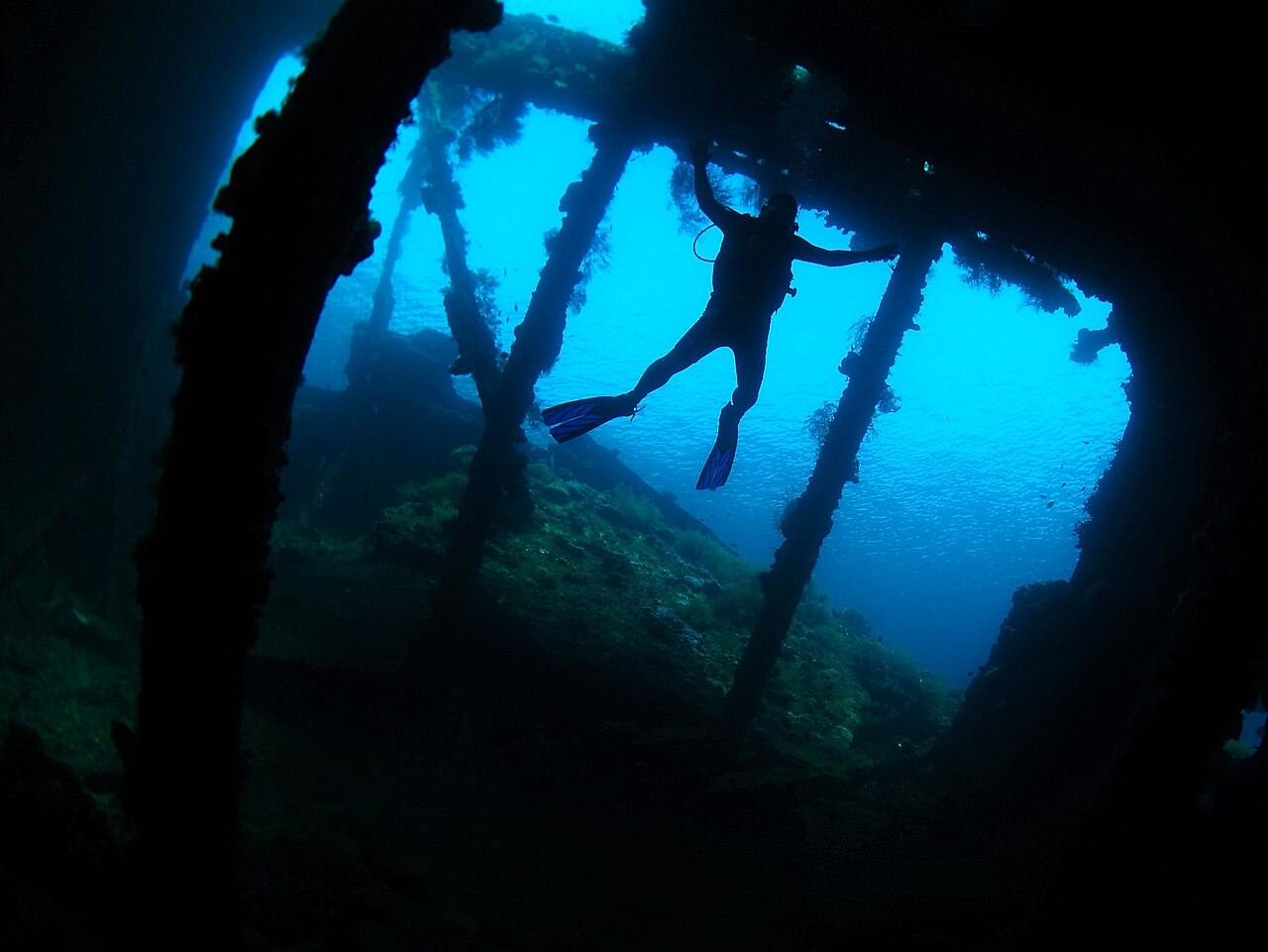 Silhouette eines Tauchers in einem Schiffswrack unter Wasser