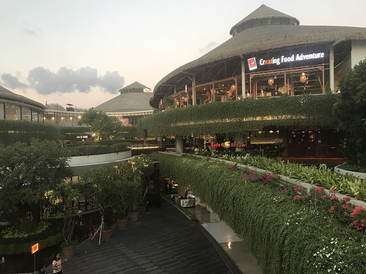 Beachwalk Shopping Center in Kuta in der Abenddämmerung, bepflanzte Terrassen und Gebäude mit Rundumdächern