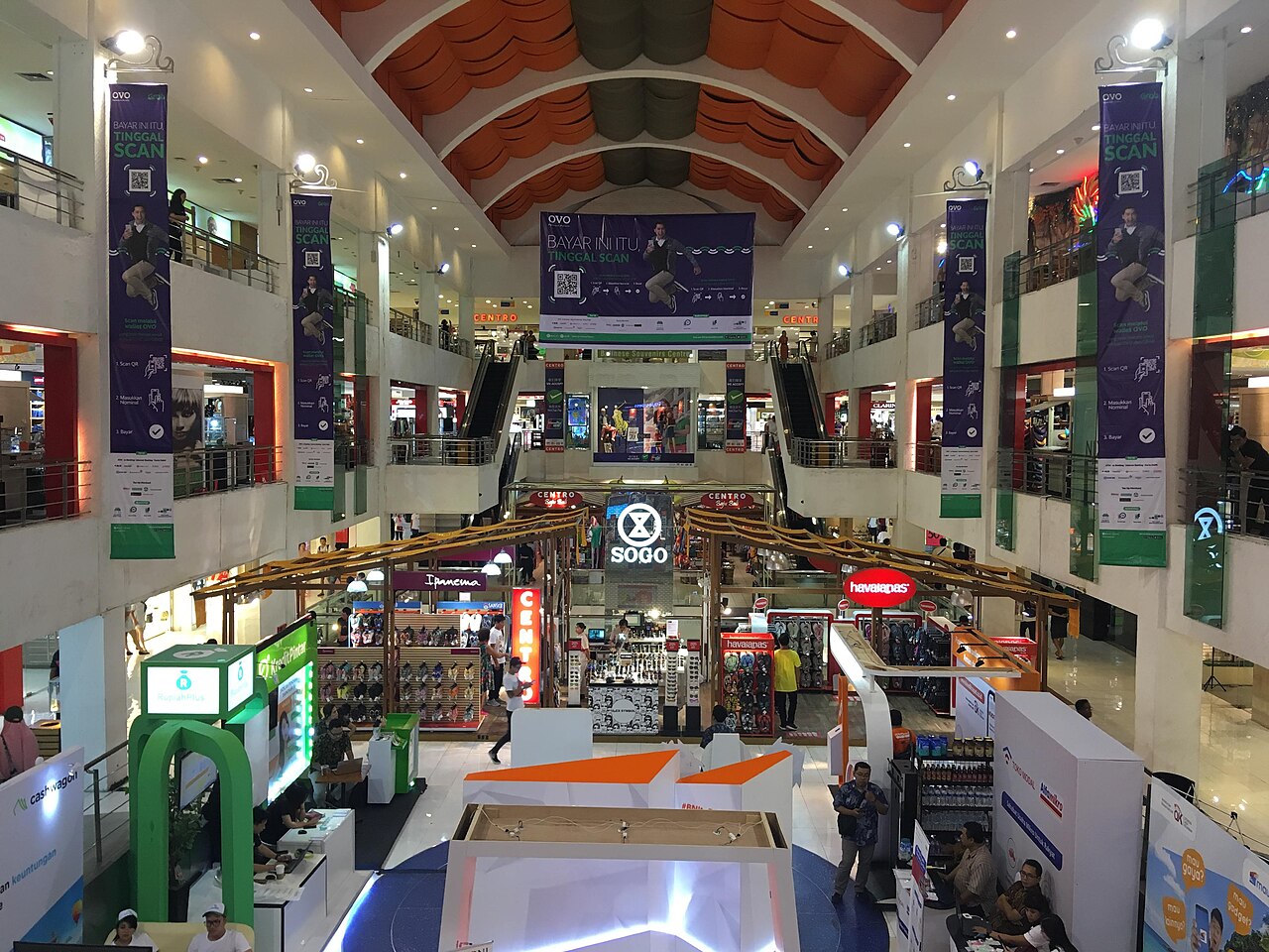Innenraum der Discovery Shopping Mall: Atrium mit Galerien, Werbebannern und Verkaufsständen im Erdgeschoss