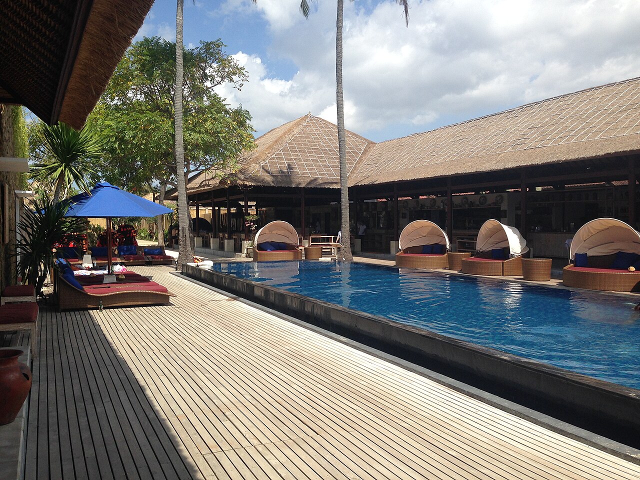 Hotelpool in Jungutbatu mit runden Liegeinseln, Sonnenschirm, Liegen und Holzterrasse