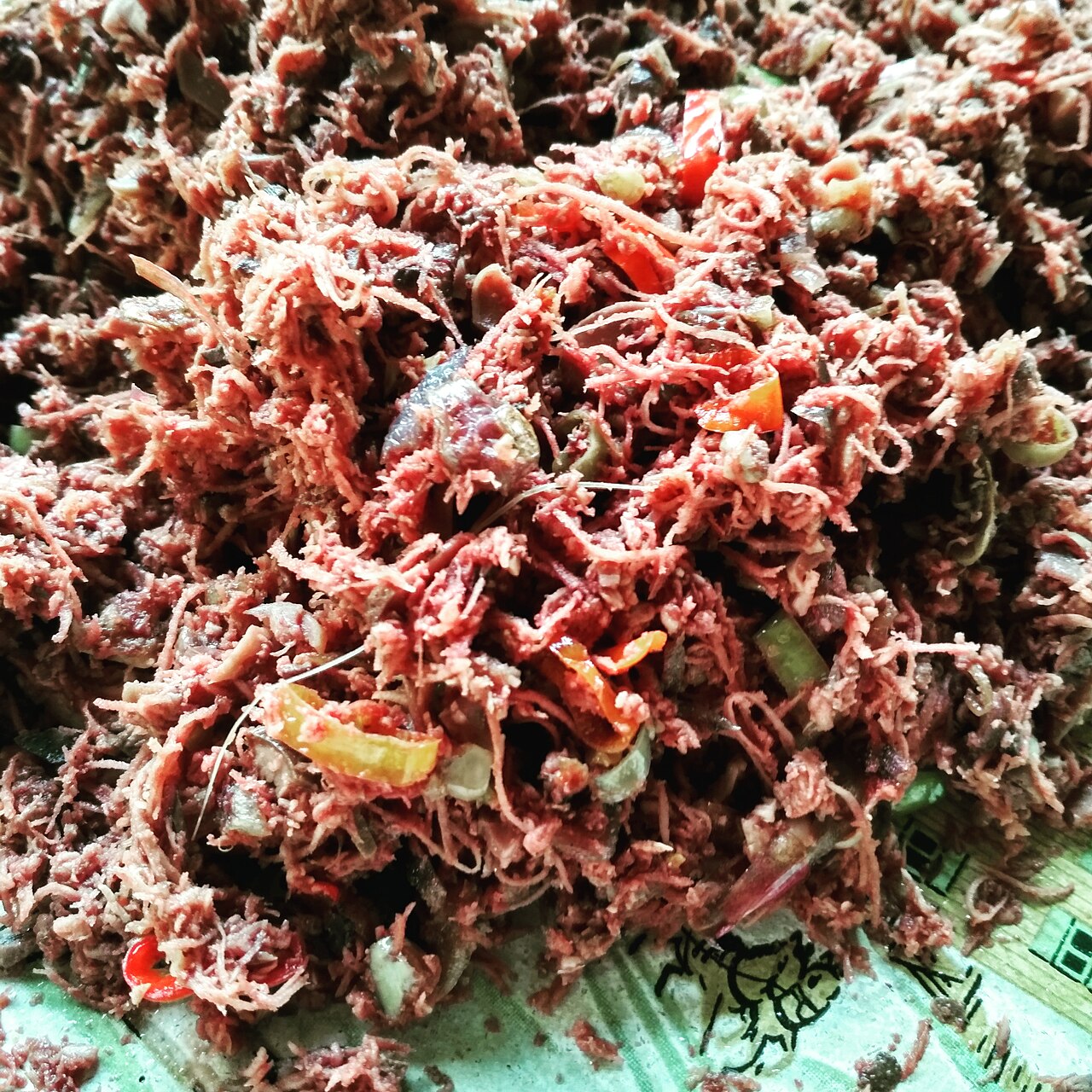Nahaufnahme von rotem Lawar mit gehacktem Fleisch, Kokosraspeln, Chili und Gewürzen