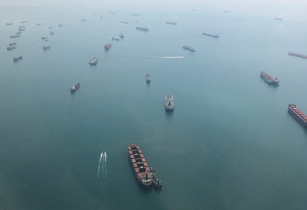 Luftaufnahme vieler Frachtschiffe auf dem Meer in der Straße von Singapur, einige davon in Fahrt